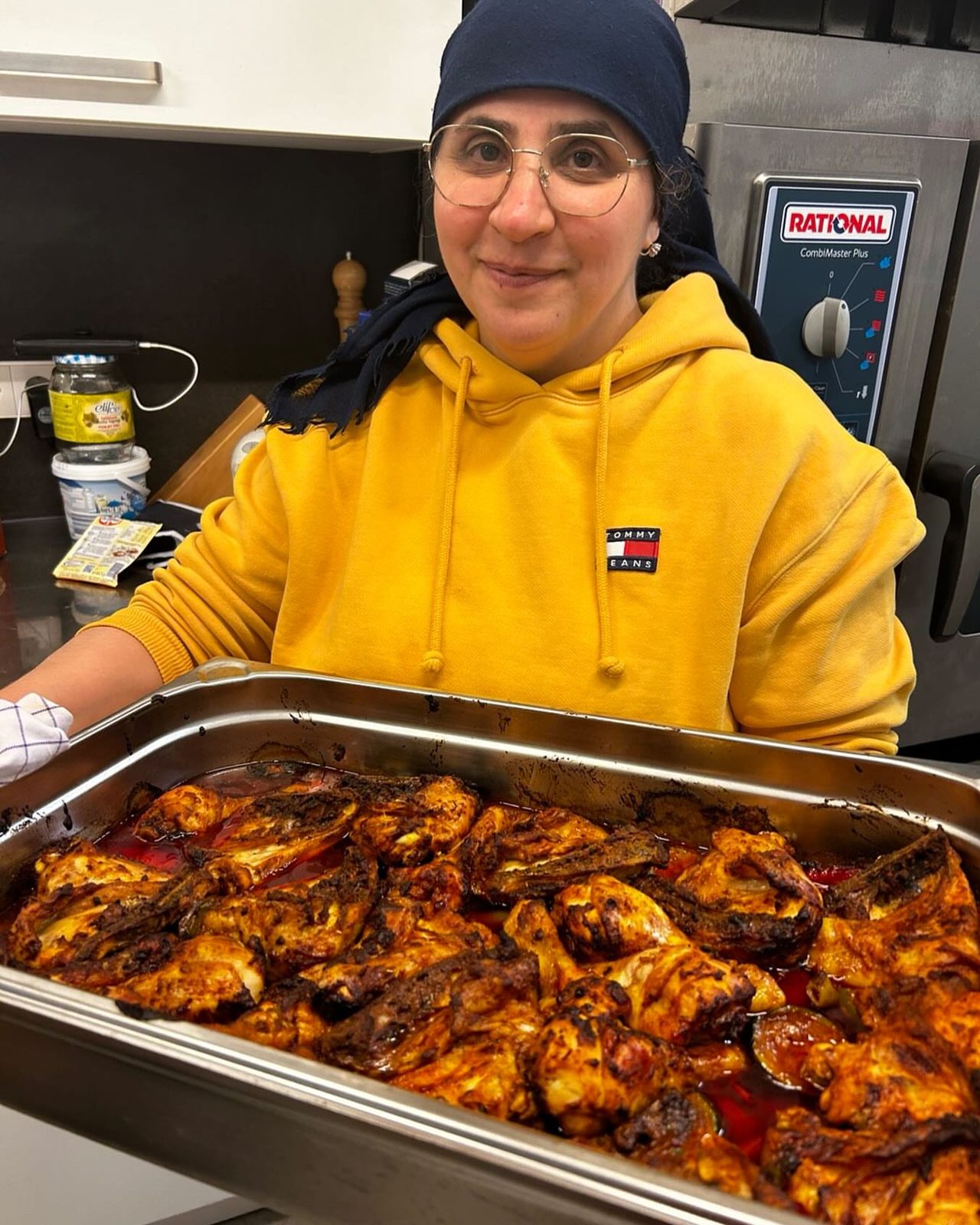 Sebiha in ihrer Cateringküche mit einer Platte frisch gegrilltem Hähnchen